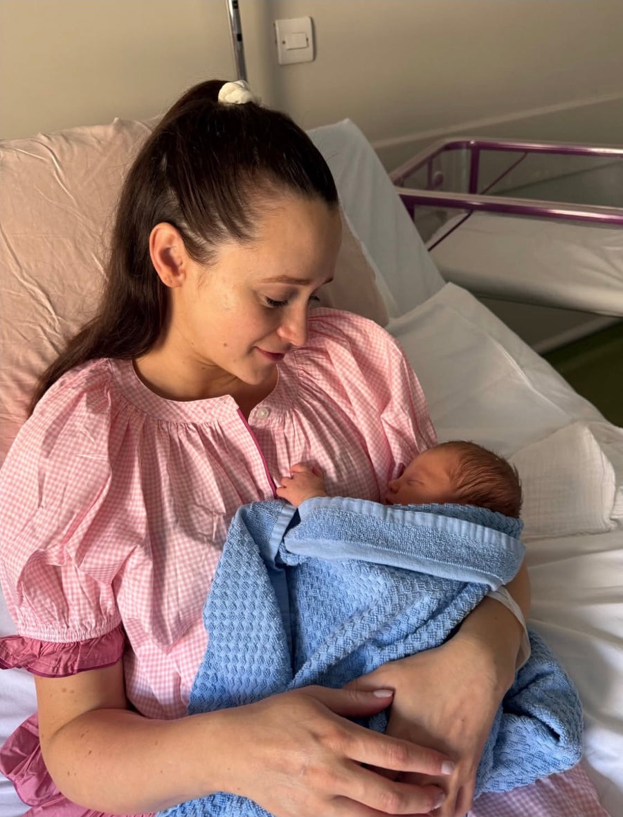 Mum holding her newborn baby while wearing the Bonnie sleep set in Soft Rose.