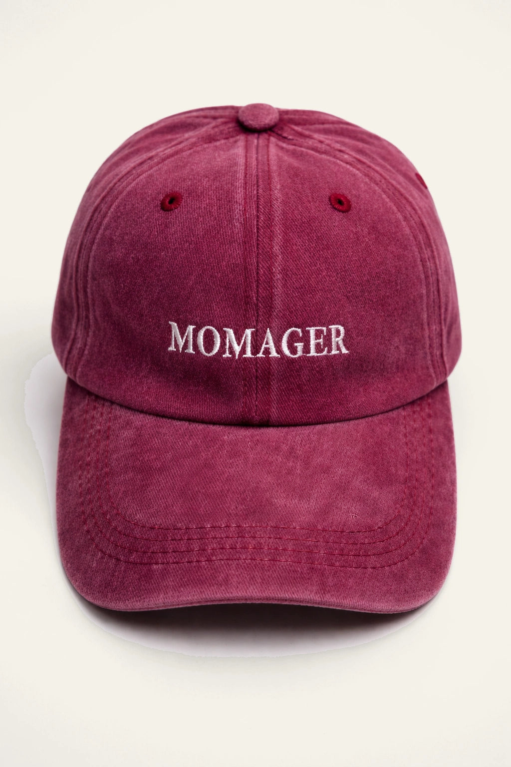 The Momager Cap shown from a side angle, highlighting the adjustable back fastening.