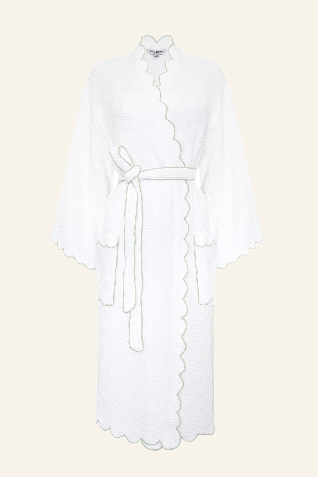 The Arabella Scallop Robe in Sage folded flat, showing the scalloped waffle texture and sage green embroidered piping.