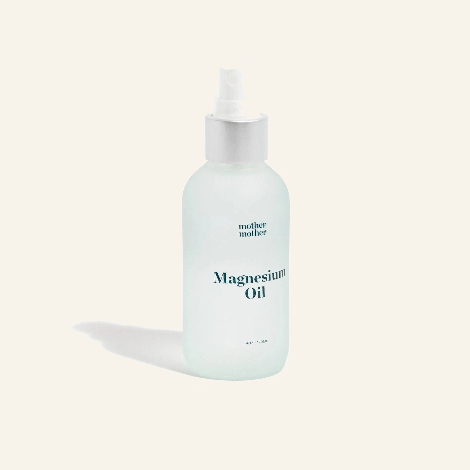 Mother Mother Magnesium Oil spray bottle held in hand, showing the spray nozzle.